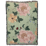Garden rose woven blanket featuring large floral patterns in pink and yellow on a green background with fringe edges.