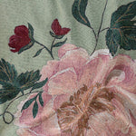 Garden rose woven blanket featuring large pink and red floral patterns on a green background.
