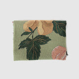 Garden rose woven blanket featuring floral patterns in soft peach and green hues, folded neatly.