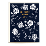 Sympathy card featuring floral designs on a navy background with the text "Grieving With You" in gold.