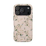 Grove iPhone case with a floral design featuring green leaves and light-colored flowers on a soft pink background.
