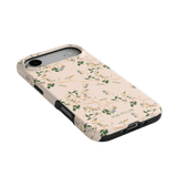 Grove iPhone case featuring a floral design in soft pink with green leaves and black edges.