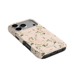 Grove iPhone case featuring a floral design in soft colors with a black trim, angled view showing camera cutout.