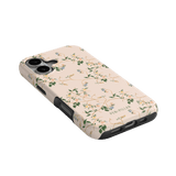Grove iPhone case featuring a floral design with green leaves and small flowers on a light pink background.