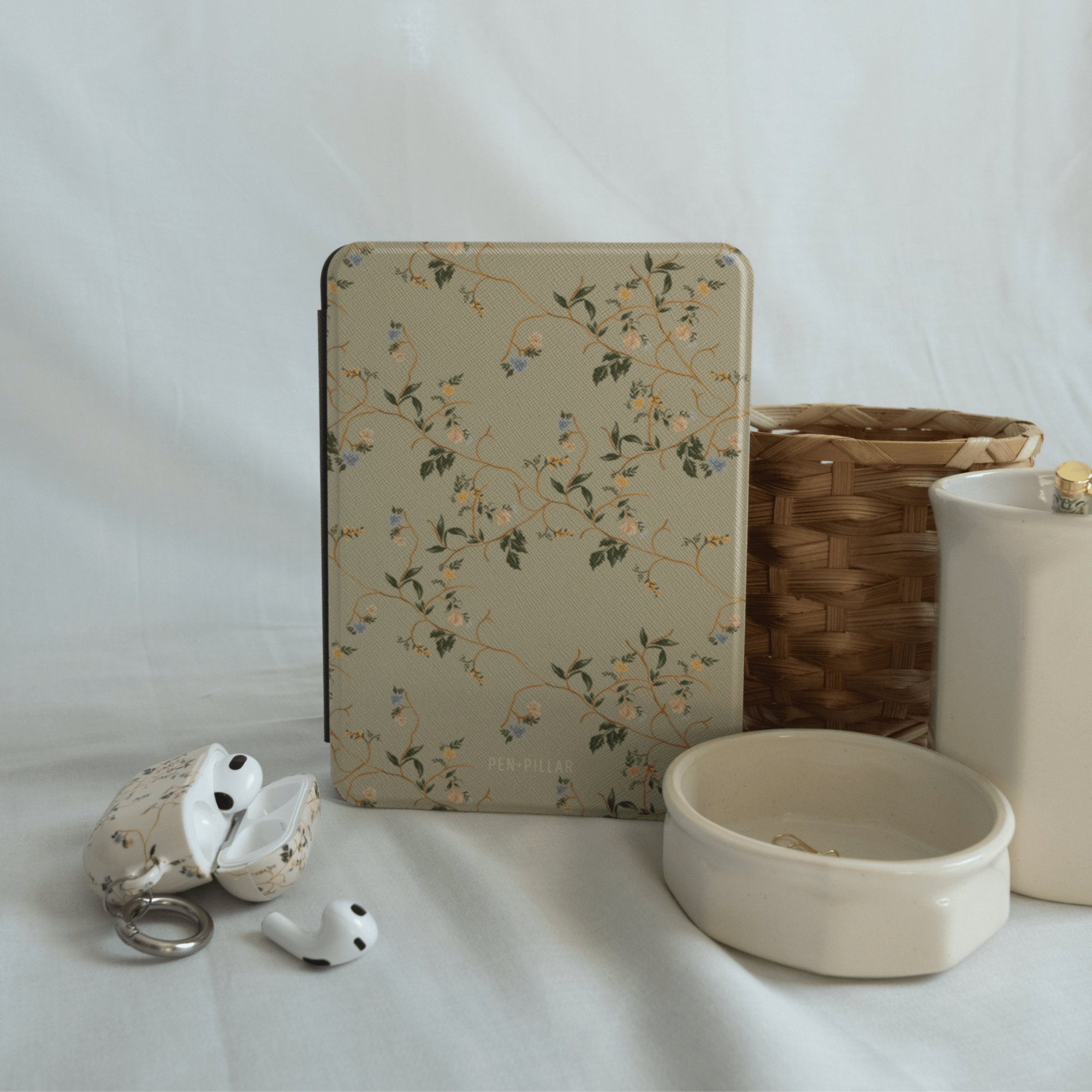 Grove Kindle case with floral design, placed against a light background with decorative items nearby.
