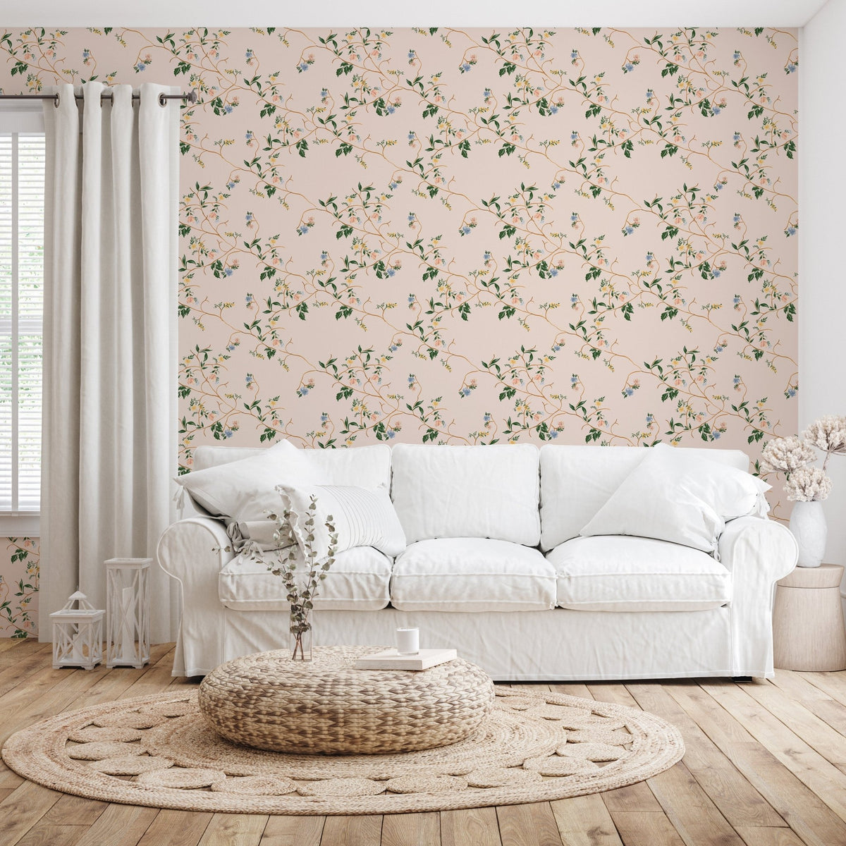 Grove Wallpaper by Pen and Pillar featuring a floral vine pattern on a pink wall behind a white fabric sofa.
