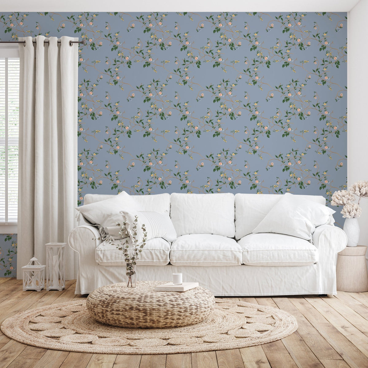 Blue Grove wallpaper with a floral vine pattern behind a white fabric sofa, woven rug, and wooden floor.