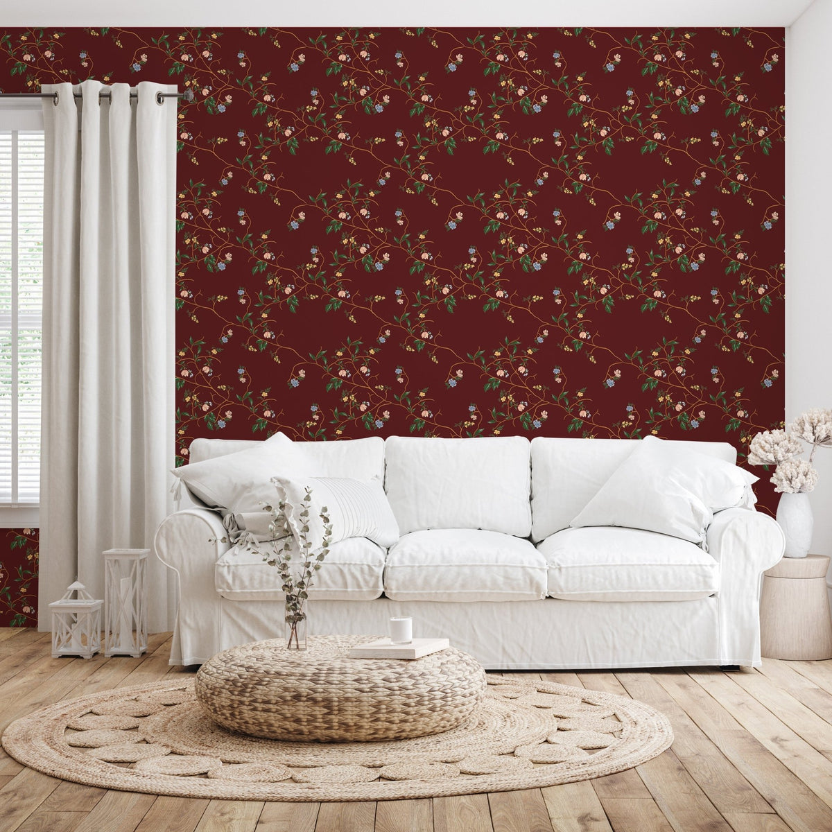 Grove Wallpaper by Pen and Pillar featuring a floral vine pattern on a dark red wall behind a white sofa.
