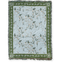 Grove woven blanket featuring a light blue background with floral patterns and green borders, fringed edges.