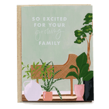 So excited for your growing family card featuring plants and a rattan chair on a green background.
