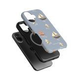 Harbor iPhone case featuring a light blue background with sailboat designs and a black phone case underneath.
