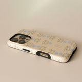 Haven personalized iPhone case with a floral pattern in blue and beige, angled view showing camera cutout.