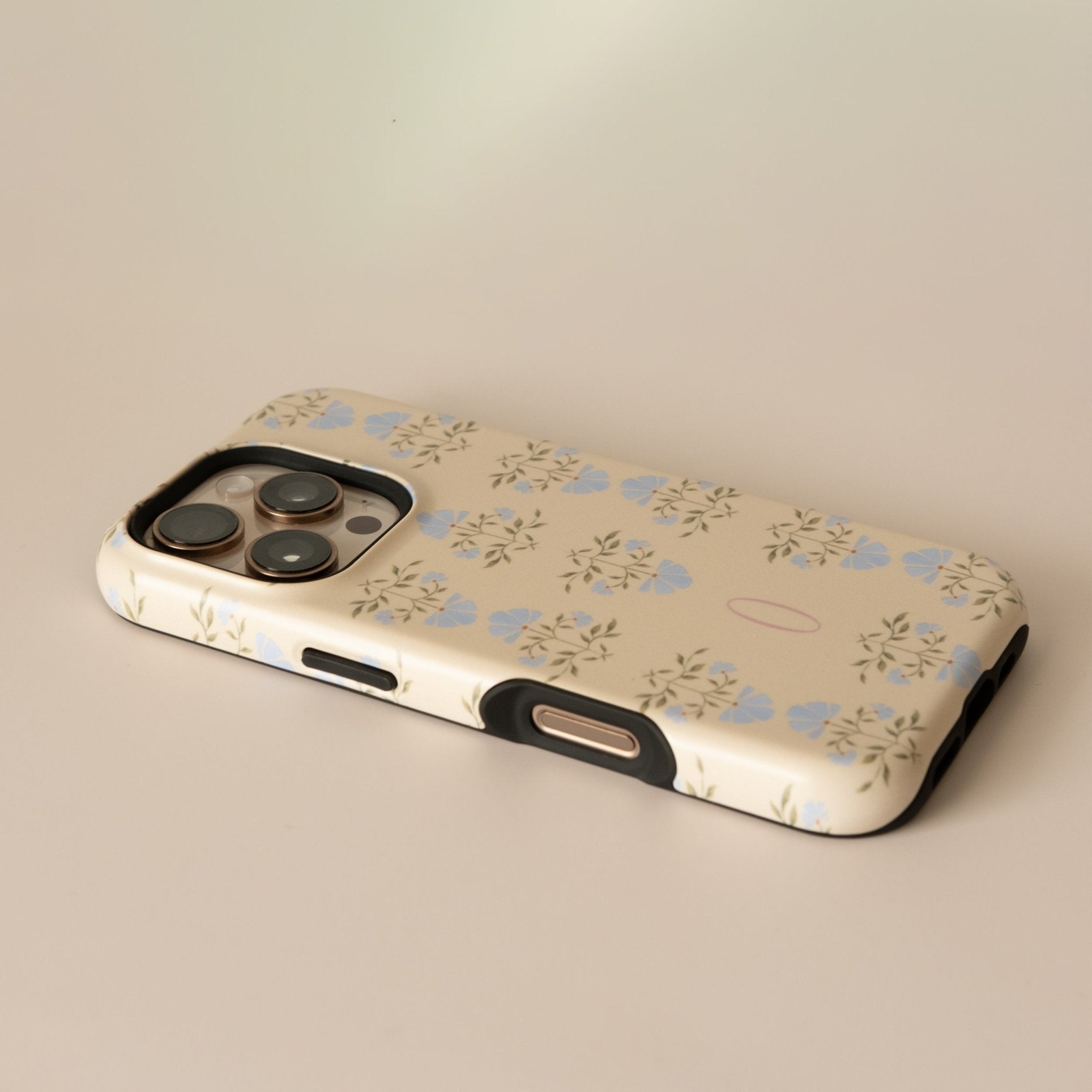 Haven personalized iPhone case with a floral pattern in blue and beige, angled view showing camera cutout.