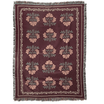 Haven woven blanket featuring a floral pattern in pink and green on a burgundy background with fringed edges.