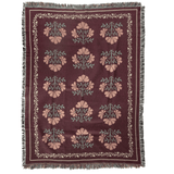 Haven woven blanket featuring a floral pattern in pink and green on a burgundy background with fringed edges.