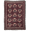 Haven woven blanket featuring a floral pattern in pink and green on a burgundy background with fringed edges.
