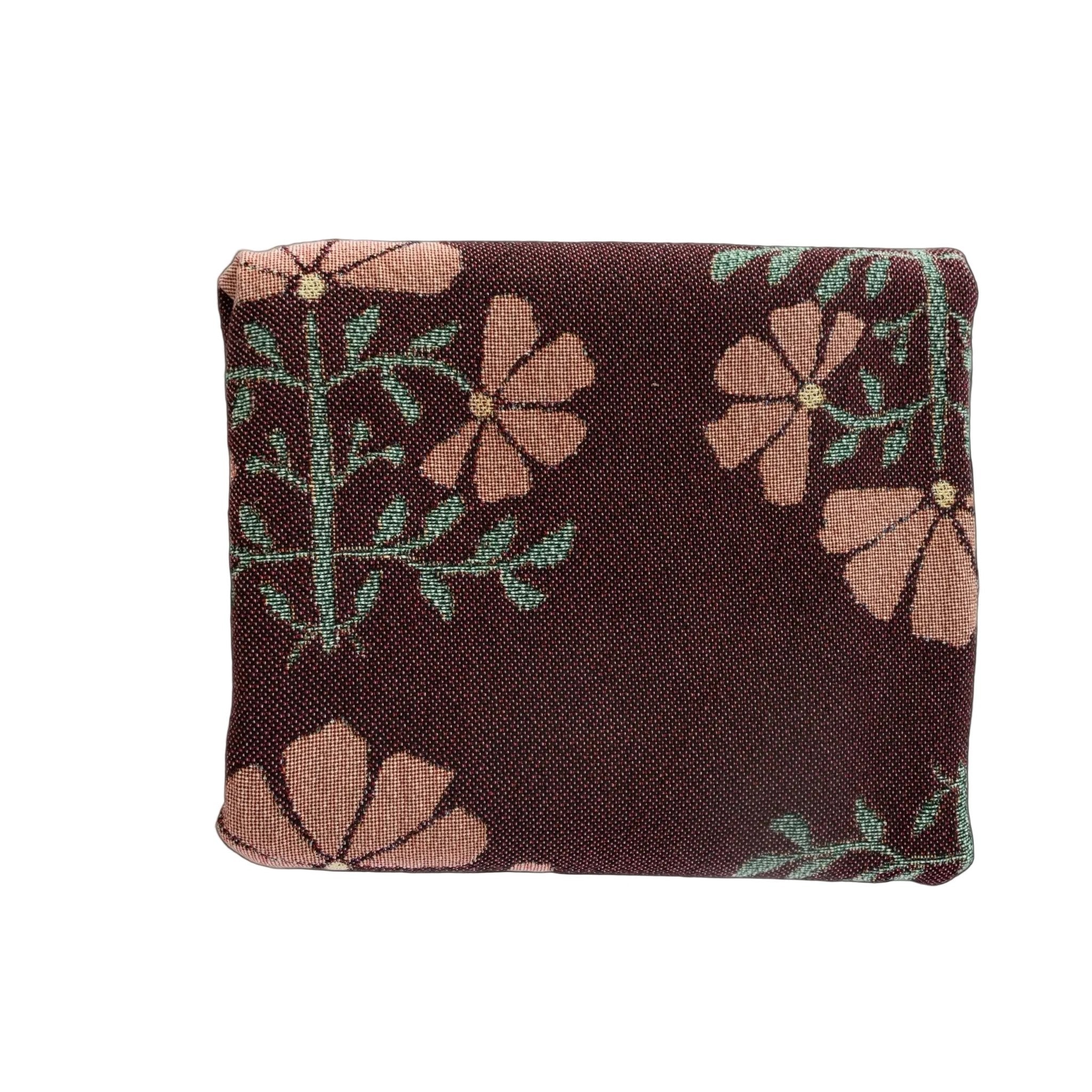 Haven woven blanket featuring a maroon background with floral patterns in pink and green.