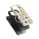 Heirloom iPhone case featuring a geometric pattern in pastel colors, layered over a black phone with a circular design.