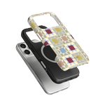Heirloom iPhone case featuring a colorful geometric pattern, layered over a black and silver phone case.
