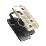 Heirloom iPhone case featuring a geometric pattern in pastel colors, layered over a black phone.