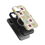 Heirloom iPhone case featuring a geometric pattern in pastel colors, layered over a black phone case.