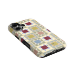 Heirloom iPhone case featuring a geometric pattern in pastel colors, angled view showing buttons and camera cutout.