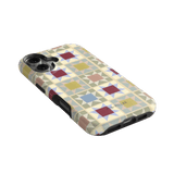 Heirloom iPhone case featuring a geometric pattern in pastel colors, angled view showing buttons and camera cutout.