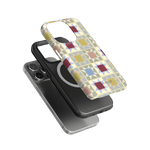 Heirloom iPhone case featuring a colorful geometric pattern, layered over a black phone case with a circular design.