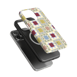 Heirloom iPhone case featuring a geometric pattern in pastel colors, shown on a black phone with a magnetic charger.