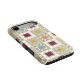 Heirloom iPhone case featuring a geometric pattern in pastel colors, angled view showing the camera cutout and buttons.