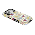 Heirloom iPhone case featuring a geometric pattern in pastel colors with a black border, angled view showing camera cutout.