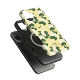 Hydrangea iPhone case featuring a floral design with white hydrangeas on a yellow background, layered over black cases.