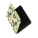 Hydrangea Kindle case with a floral design in white and green on a yellow background, partially open to show the screen.