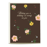 Marigold birthday card featuring floral designs on a dark brown background with the text "Wishing you a birthday as lovely...