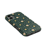Meadow iPhone case featuring a floral pattern on a dark green background, angled view showing camera cutouts.