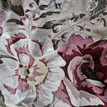 Meadow woven blanket featuring a floral pattern in shades of red, pink, and cream on a textured background.