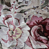 Meadow woven blanket featuring a floral pattern in shades of red, pink, and cream on a textured background.