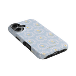 Merrigold iPhone case featuring a light blue floral pattern with a textured surface and black edges.