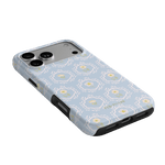 Merrigold iPhone case featuring a light blue floral pattern with black edges, angled to show camera cutouts.