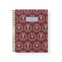 Merrigold notebook with a maroon cover featuring floral patterns and a gold spiral binding.