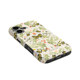 Monarch iPhone case featuring a floral and butterfly design with a black border, angled view on a green background.