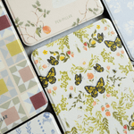 Monarch Kindle case featuring a floral design with butterflies in yellow and green on a white background.
