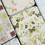 Monarch Kindle case featuring a floral design with butterflies in yellow and green on a white background.