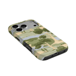Orchard iPhone case featuring a landscape design with trees and a soft color palette, angled view showing ports.