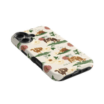 Pasture iPhone case featuring floral designs and cows on a cream background, angled to show the side and buttons.