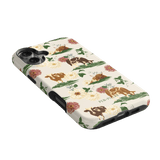 Pasture iPhone case featuring floral and cow illustrations on a cream background with black edges.
