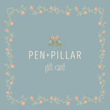 Gift card design featuring "Pen + Pillar" text with floral border on a light blue background.