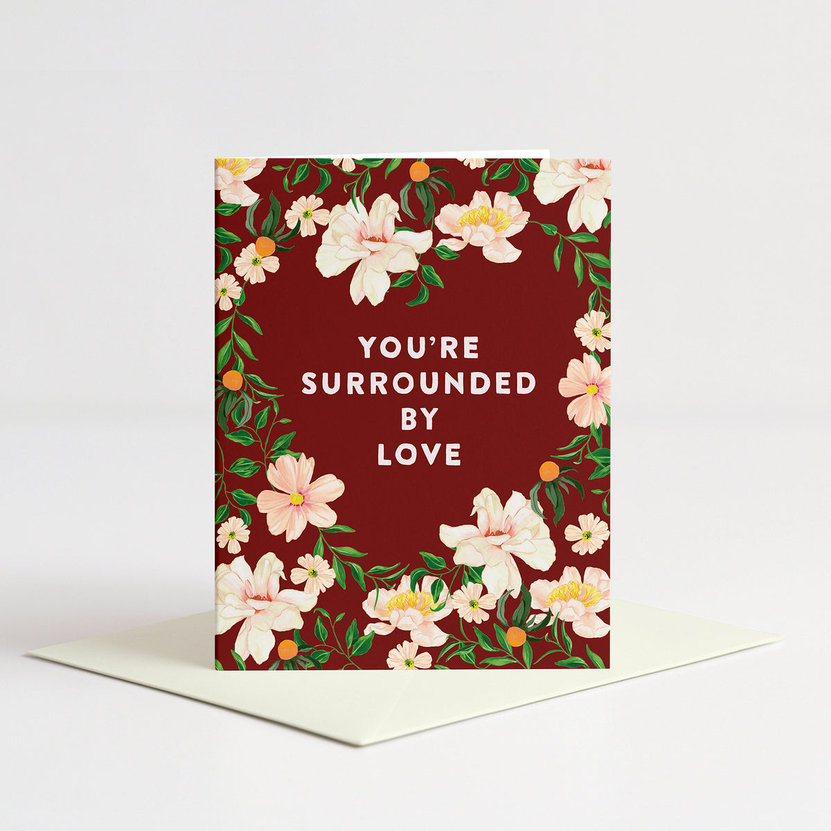 Surrounded By Love Sympathy Card standing on a natural cream envelope