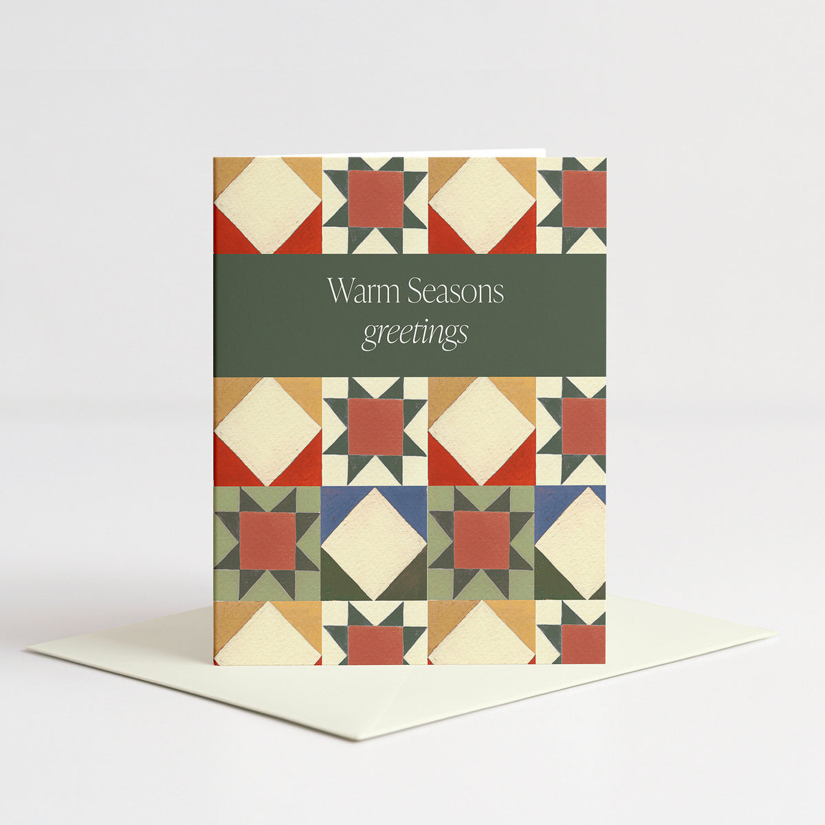 Quilt Holiday Card standing on a natural cream envelope
