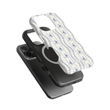 Riviera iPhone case featuring a floral pattern in blue on a white background, layered over a black phone case.